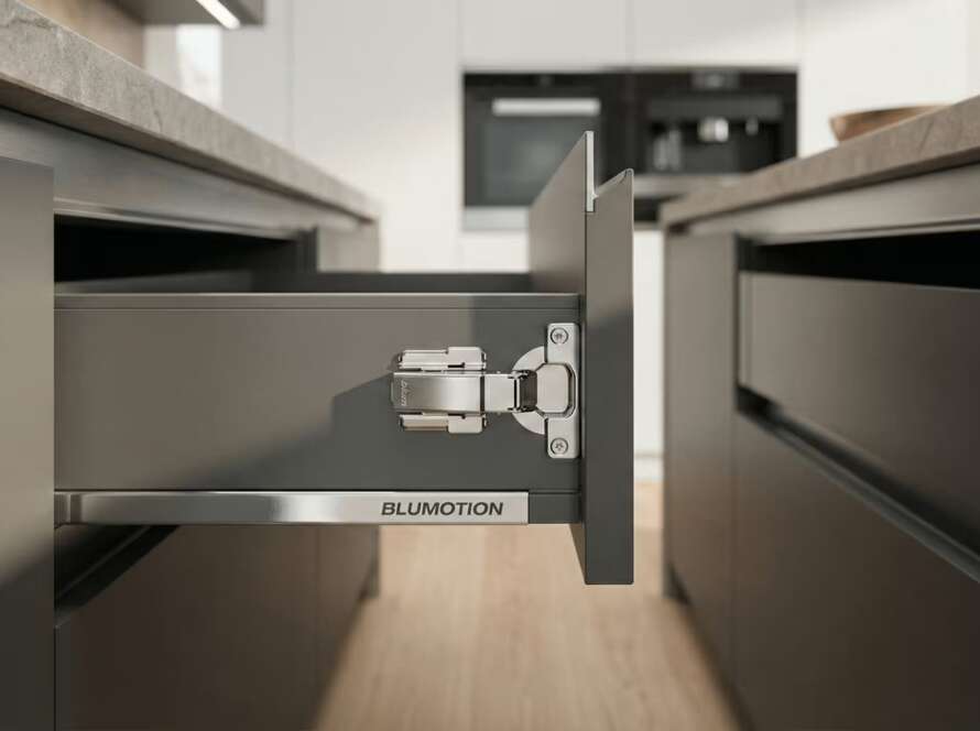 Detalle de bisagra Blum Clip Top con sistema de amortiguación Blumotion instalada en mueble de cocina moderno.